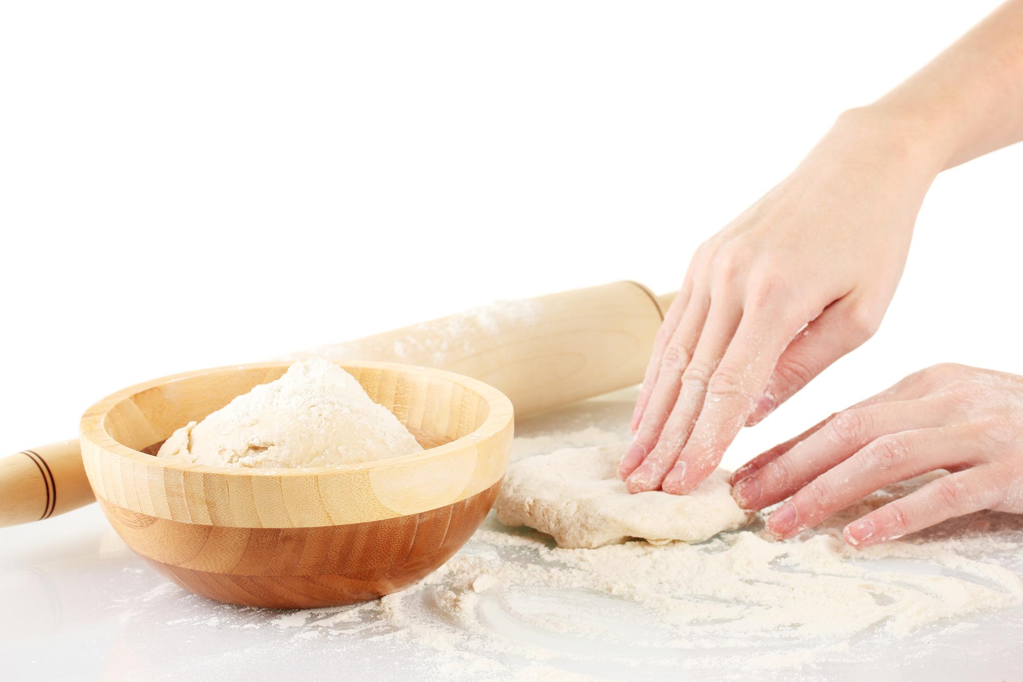 Dettaglio di mani che impastano pane in cucina